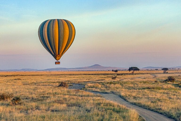 Hot air balloon flying over the Serengeti Plains during a sunrise safari in Tanzania